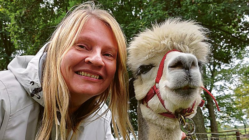 Portrait: Autorin Kirsten Wagner posiert mit einem Alpaka