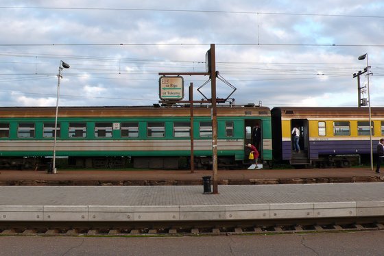 Ein alter Zug am leeren Bahnhof von Riga. Eine Frau steigt aus, eine ein.