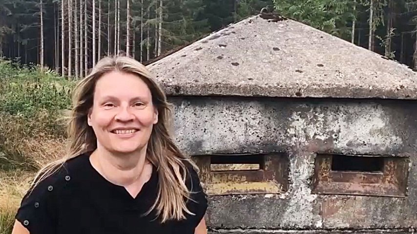 Autorin Kirsten Wagner vor einem Beobachtungsturm im Wald an der ehemaligen deutsch-deutschen Grenze 