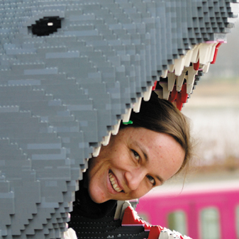 Portrait: Autorin Ingrid Retterath lugt aus einem Haumaul aus Legosteinen