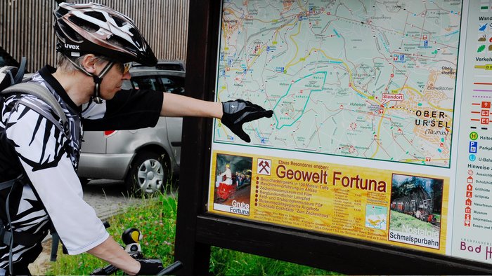 Fahrradfahrer liest Infotafel