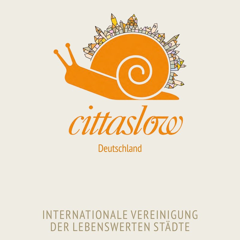 abstrakte orange Schnecke mit Häusern auf Schneckenhaus: Logo der cittaslow Deutschland e.V.
